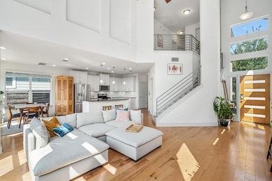 Living area featuring a towering ceiling, stairwa