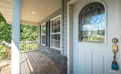 Property entrance with a porch and stone siding