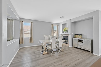 Dining space featuring a fireplace and light wood-type flooring