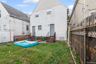 Rear view of house featuring a fenced backyard and entry steps