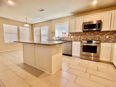 Kitchen with appliances with stainless steel finishes, dark stone countertops, backsplash, a kitchen island, and pendant lighting