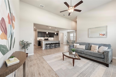 Living room featuring a high ceiling, light wood-