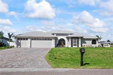 View of front of home with a front yard and a gara