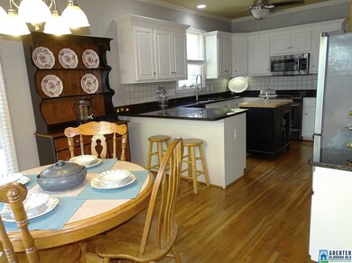 The kitchen includes hardwood flooring and granite