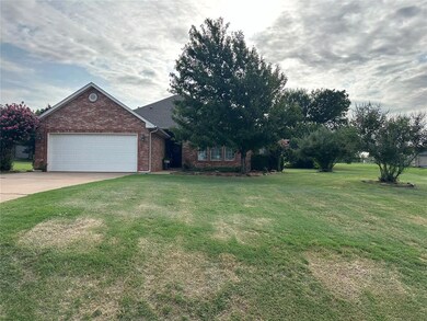 View of front of home with a front yard and a gara