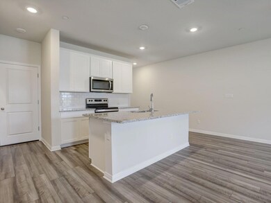 Kitchen with stainless steel appliances, light wo