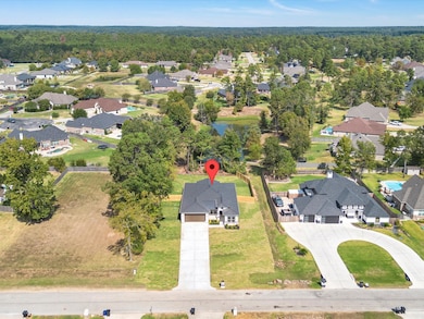 Green space and neighborhood pond flank this half acre home site