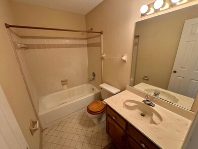 Full bathroom with a textured ceiling, vanity, toi