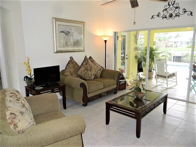 Living room with sliders opening to pool deck.