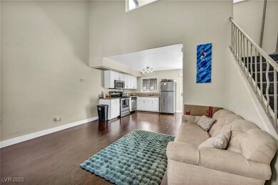 Living area with dark wood-style floors, stairs, b