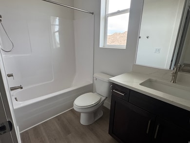 Full bathroom featuring vanity, dark wood-style floors, and shower / bath combination