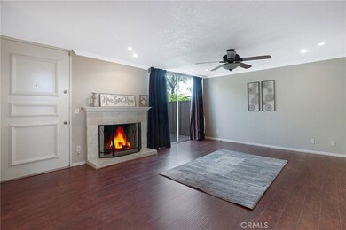 Living room with fireplace and glass slider doors leading to outdoor patio. Notre crown molding throughout.