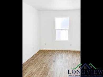 Spare room featuring baseboards and wood finished floors