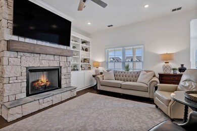The spacious Living Room offers extras such as crown molding, custom built-ins, a gas fireplace with mantle/stone accents and recessed lighting...