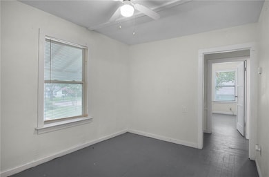 Empty room with a ceiling fan, dark wood-style flo