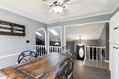 The spacious dining room features a vaulted ceiling, crown molding, and ceiling fan.