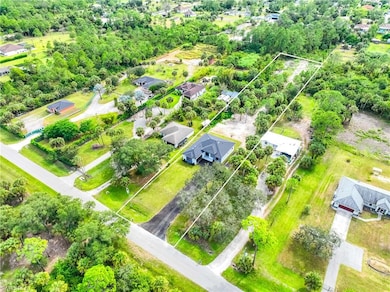 Aerial view of residential area featuring property parcel outlined and a tree filled landscape