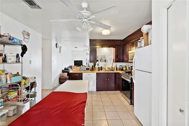 Kitchen featuring a ceiling fan, a sink, white app