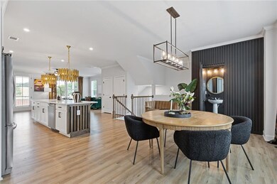Dining area featuring a chandelier, light wood-style flooring, ornamental molding, and recessed lighting