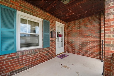 Property entrance with brick siding and a porch