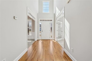 Entryway featuring baseboards, a high ceiling, and