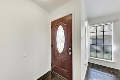 Foyer with baseboards and dark wood-style flooring