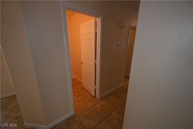 Hallway featuring light tile patterned floors and