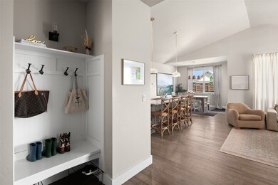 Mudroom with wood finished floors and high vaulted ceiling