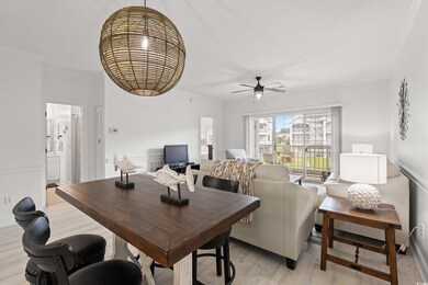 Dining room featuring ornamental molding, light wood-style flooring, and ceiling fan