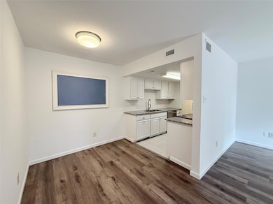 Kitchen with a sink, wood finished floors, white 