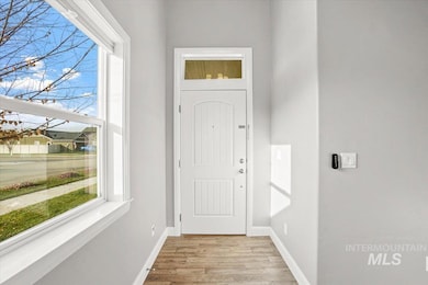 Doorway to outside with baseboards and wood finished floors