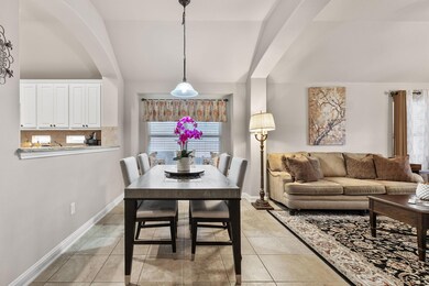 Dining space with lofted ceiling, light tile patt