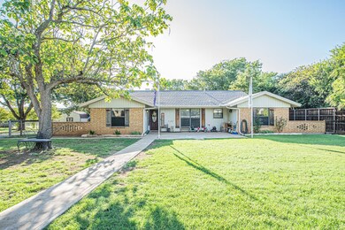 Ranch-style house featuring a front lawn and a patio
