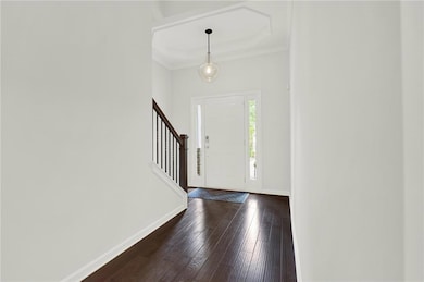 Entrance foyer with stairs, baseboards, dark wood-