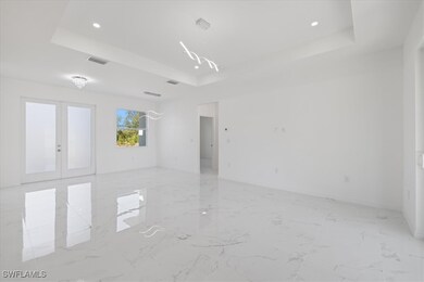 Empty room with a tray ceiling, recessed lighting,