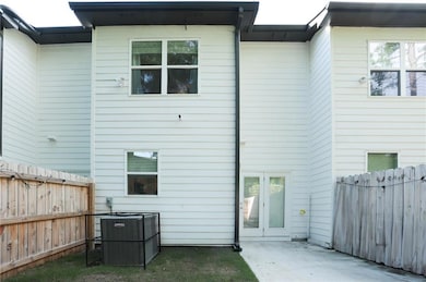 Back of property with central AC, a patio area, and a fenced backyard