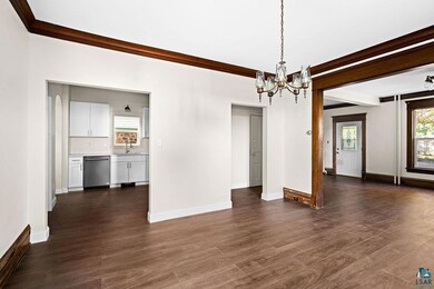 Empty room featuring ornamental molding, dark hard