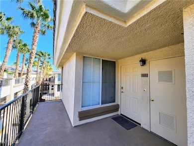 Entrance to property with stucco siding and a balcony