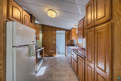 Kitchen featuring white appliances, lofted ceiling