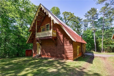 View of side of home with a lawn and metal roof