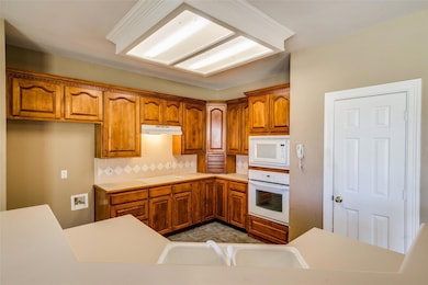 Kitchen with tasteful backsplash, white appliances