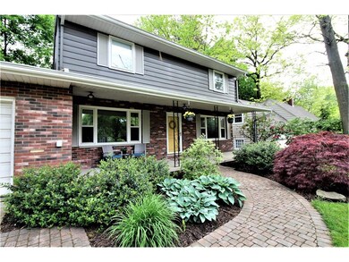 Welcoming Front Porch Surrounded by Beautiful Gard