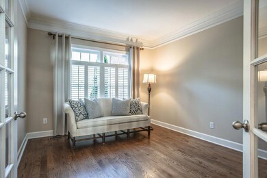 The office is just to the left of the foyer. Notice the large bank of windows and french doors for privacy.