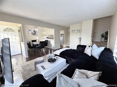 Living room featuring wood finished floors, a textured ceiling, and stairs