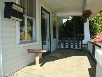 Exterior Front. Charming front porch ... great spot for your morning coffee, curved staircase