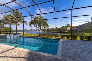 View of pool featuring an in ground hot tub, a patio, a water view, and glass enclosure