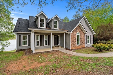 Cape cod house with stone siding, covered porch, a