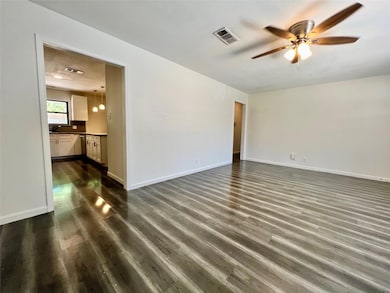 Spare room with a ceiling fan, dark wood-style fl