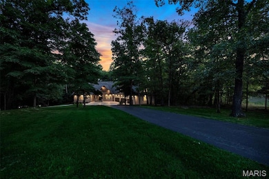 View of front facade featuring a front yard and asphalt driveway