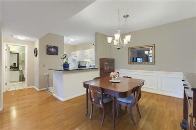 Dining space with light wood flooring and a chandelier